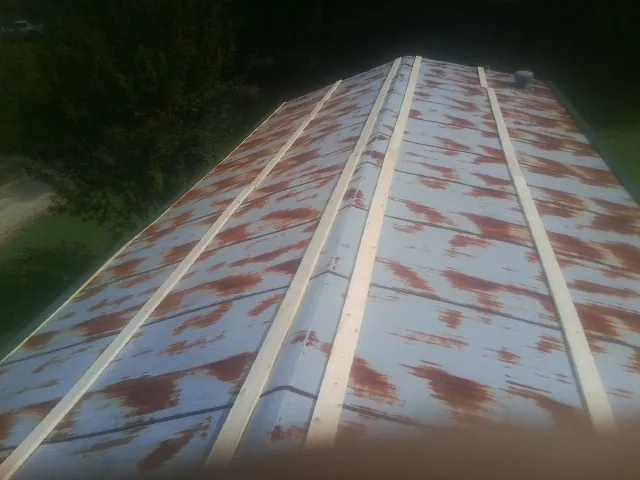 Rusted metal roof panels with new wood purlins before replacement — Storm Damage Roof Repair in Parrott by Roofing Brothers