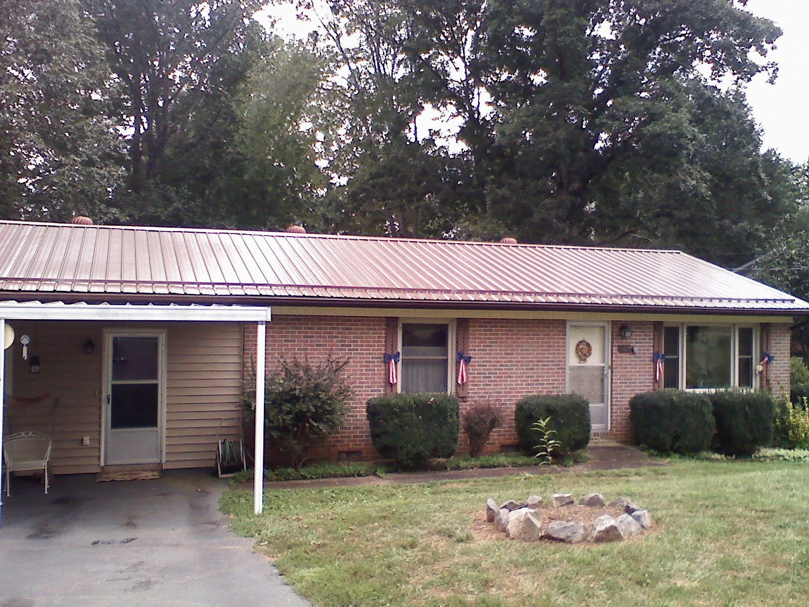 Bronze metal roof and carport on a brick ranch home — Roof Repair work by our crew in Parrott